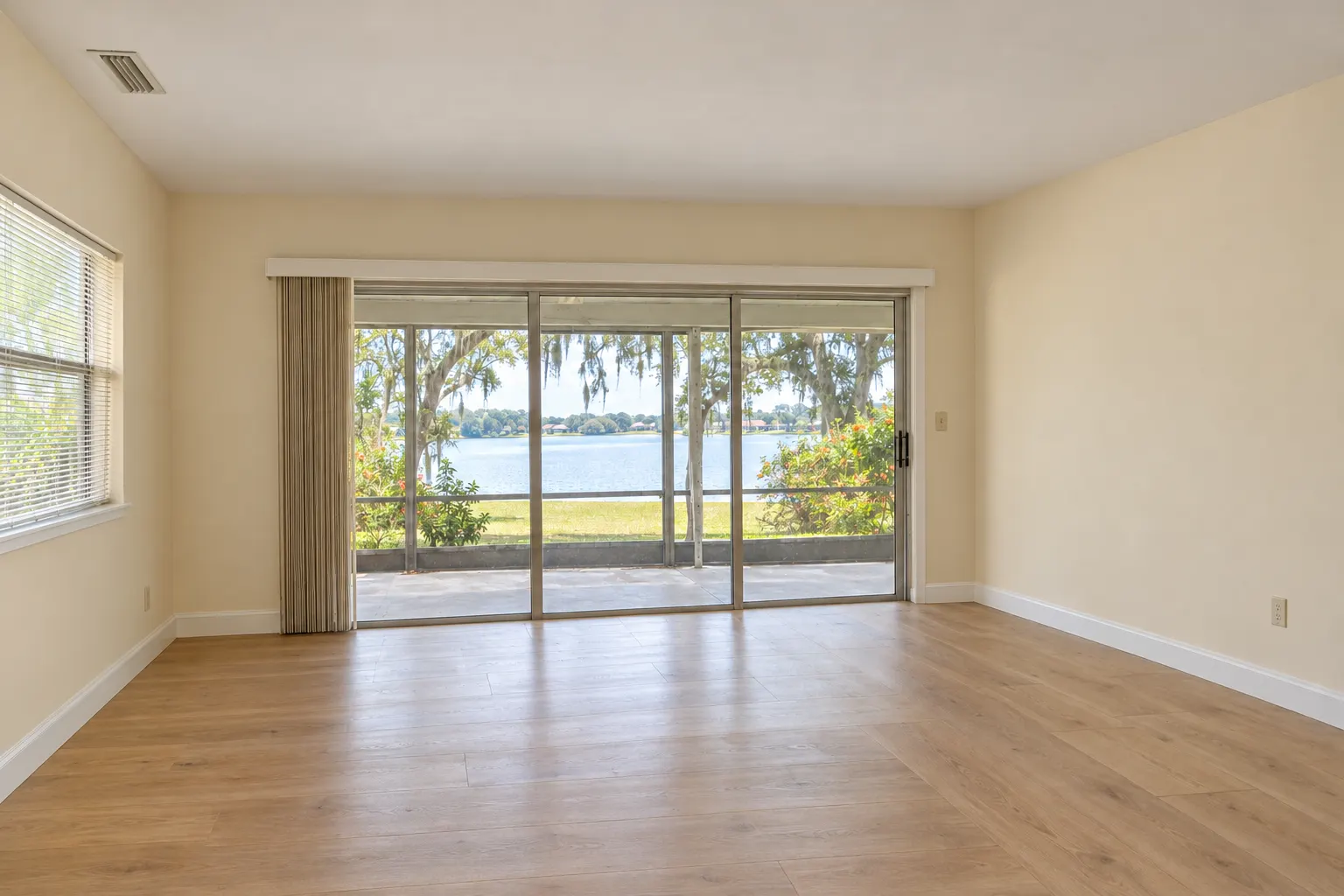 Example image, not one of our jobs: the same living room renovated, with a smooth white ceiling, fresh cream walls, new white baseboards and a plank floor.